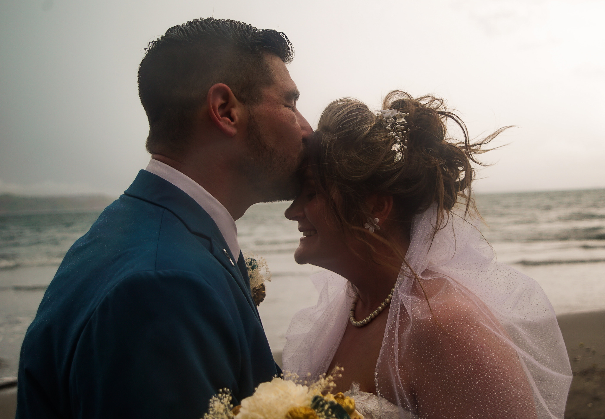Zack kissing Brandi on the forehead at the beach